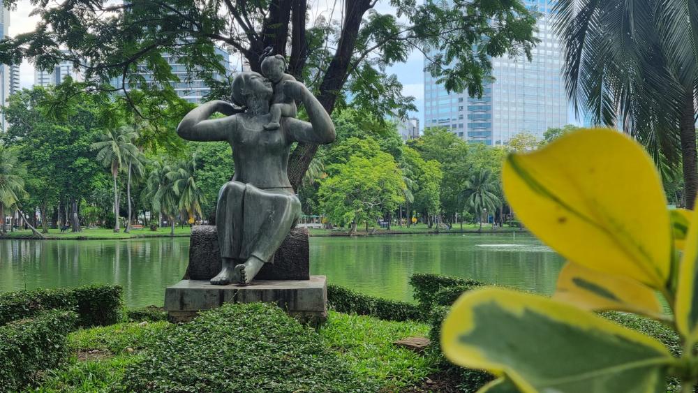 Au parc Lumpini de Bangkok, la statue d'une mère portant son enfant célèbre la natalité. © Esther Dabert